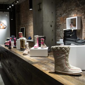 Boots displayed on white lacquer rectangle waterfall display sets in a retail store