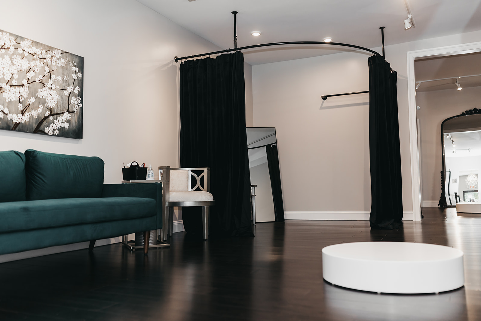 Fitting room with a black curtain and teal sofa